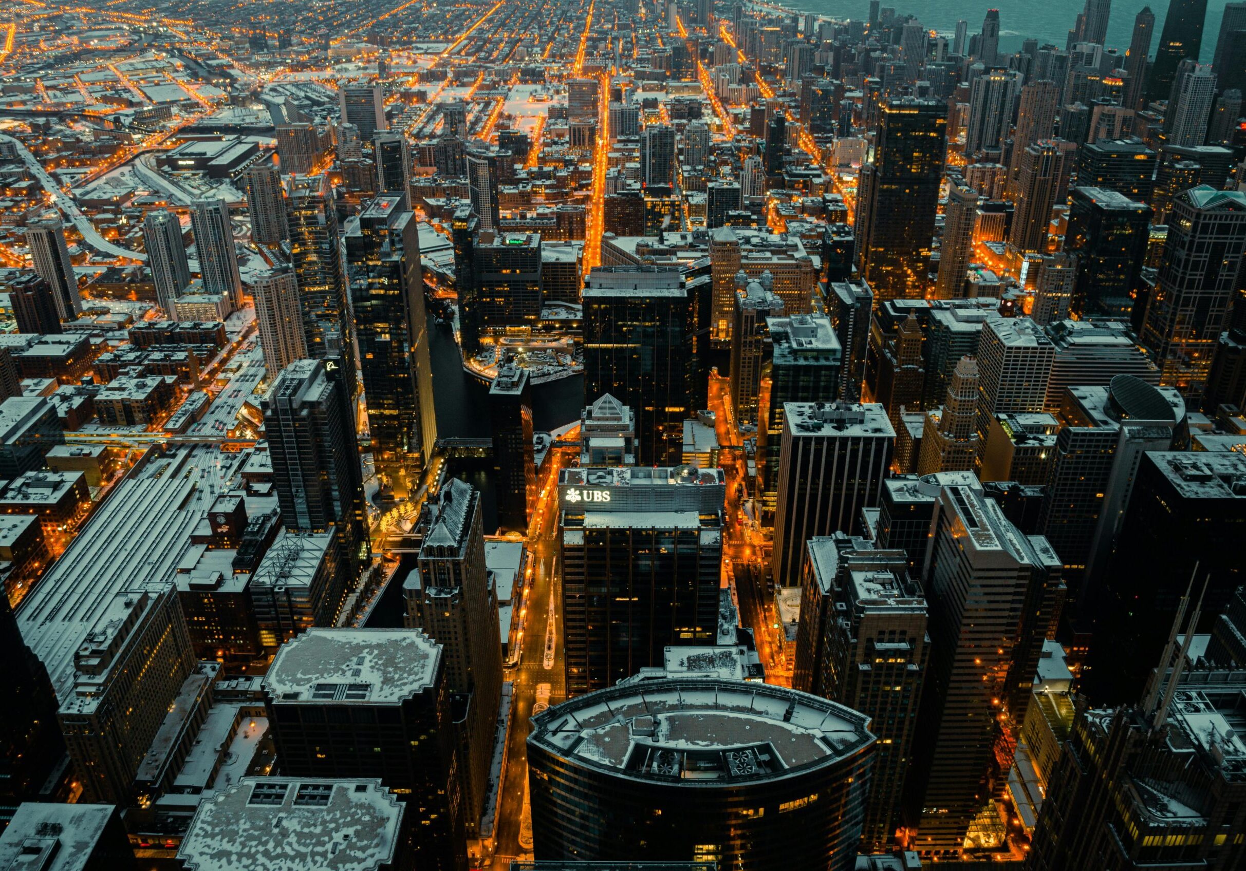 Stunning aerial view of Chicago's illuminated skyline dusted with snow at twilight.